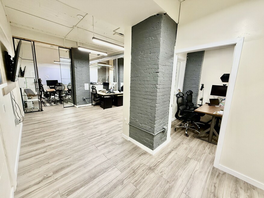 Open office with exposed brick columns and workstations