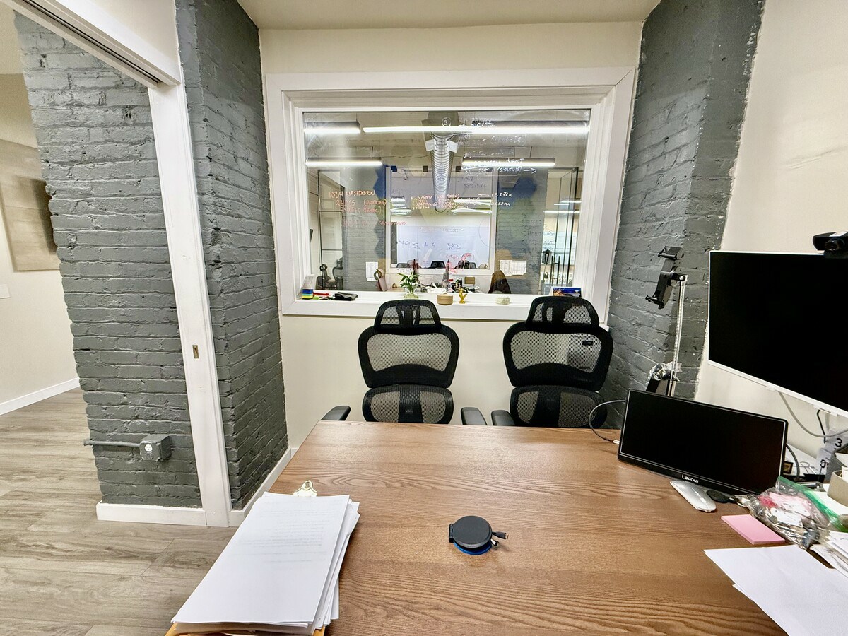 Private office with window overlooking open workspace