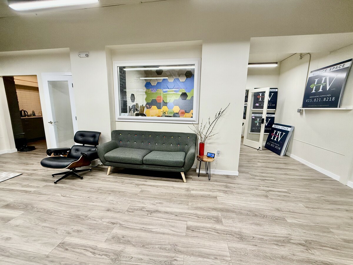 Lounge area with Eames chair, sofa, and reception signage